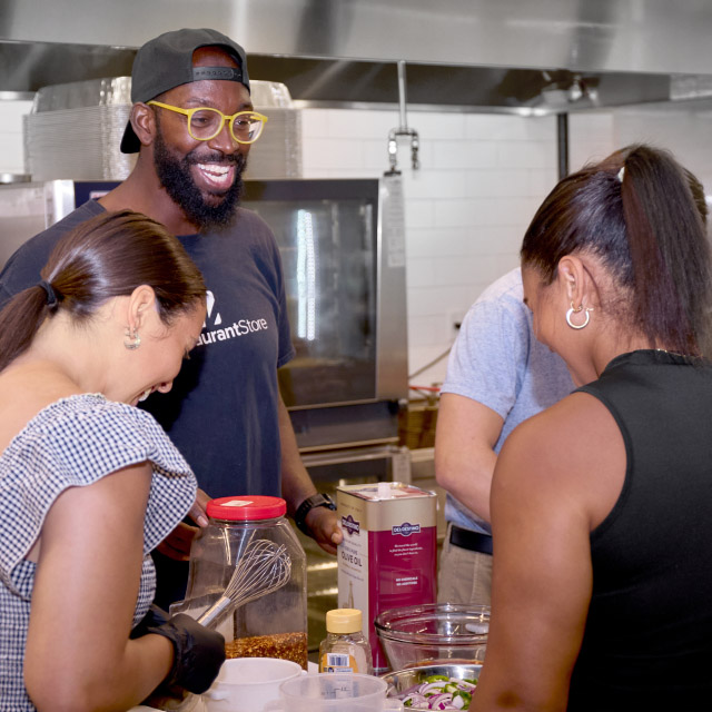 Smiling chef and staff in a commercial kitchen